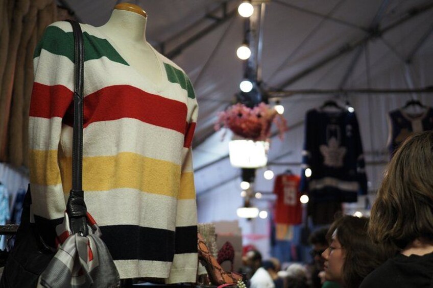 A mannequin wearing a striped sweater with a black shoulder bag. 4