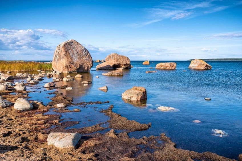 A rocky shoreline with large boulders in calm water. 3