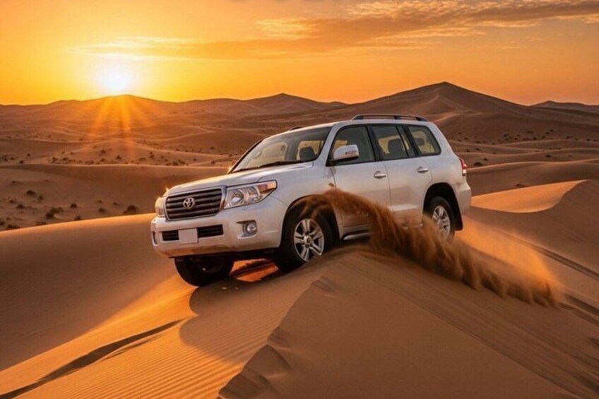 A white SUV driving through sand dunes at sunset. 4
