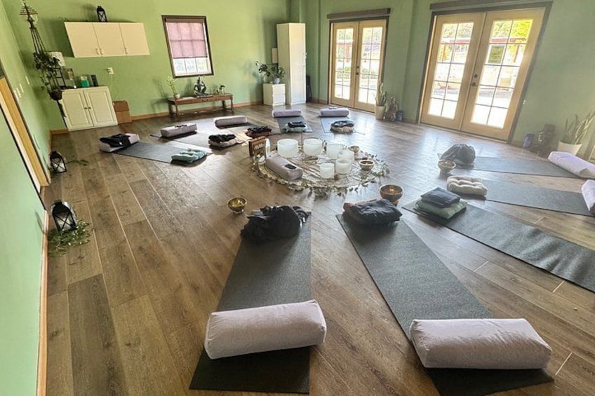 A yoga studio with mats, cushions, and a central meditation area. 2