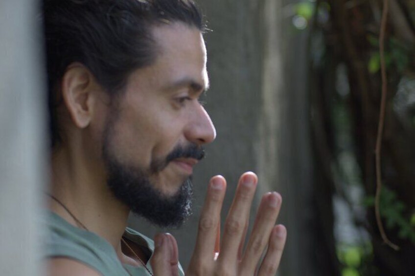 Una persona con barba y bigote, usando una camiseta sin mangas, con la mano parcialmente visible. 4