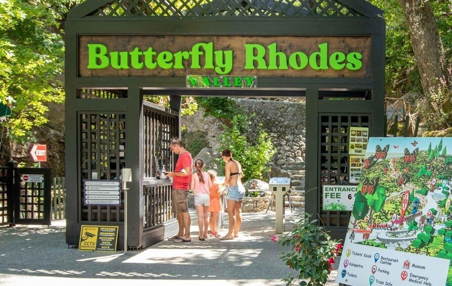 A Butterfly Rhodes sign with a map and a ticket kiosk. 1