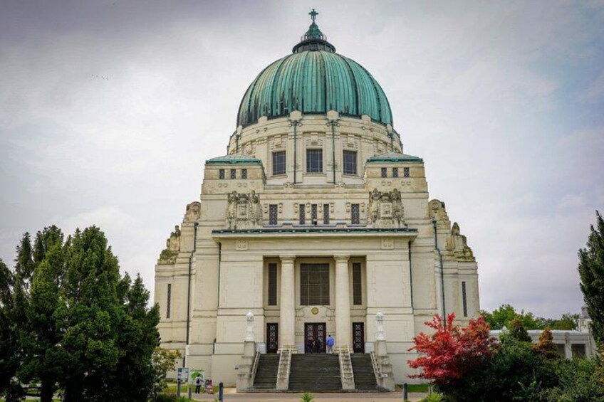 A large building with a green dome, a central entrance, and steps leading up to it. 2