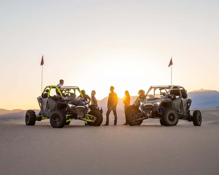 Two off-road vehicles with flags, people in helmets, and a desert landscape with mountains in the background. 5