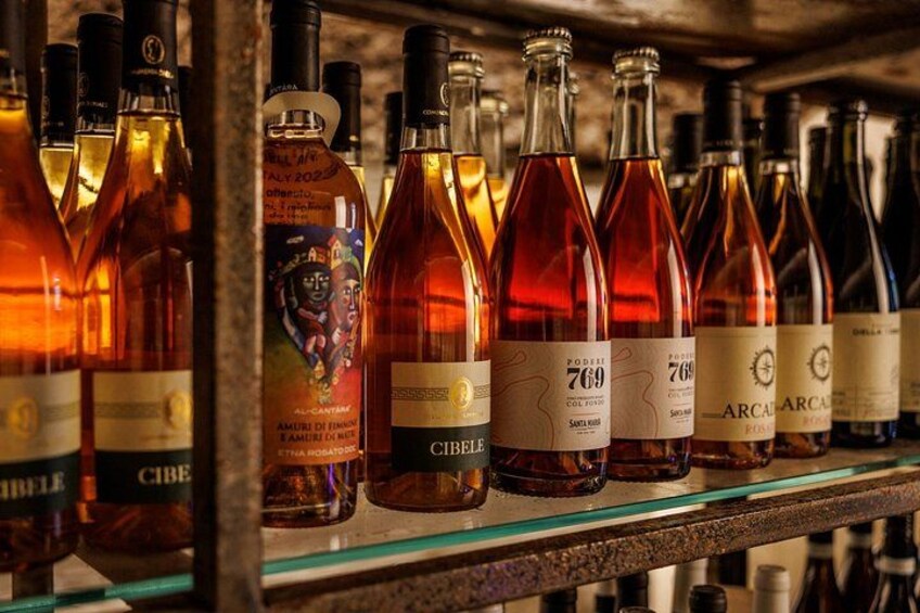 Una fila de botellas de vino en un estante. 5