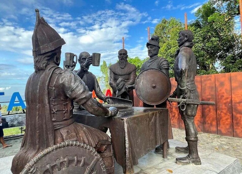A bronze statue of a medieval scene with a knight, a squire, and a drummer. 1
