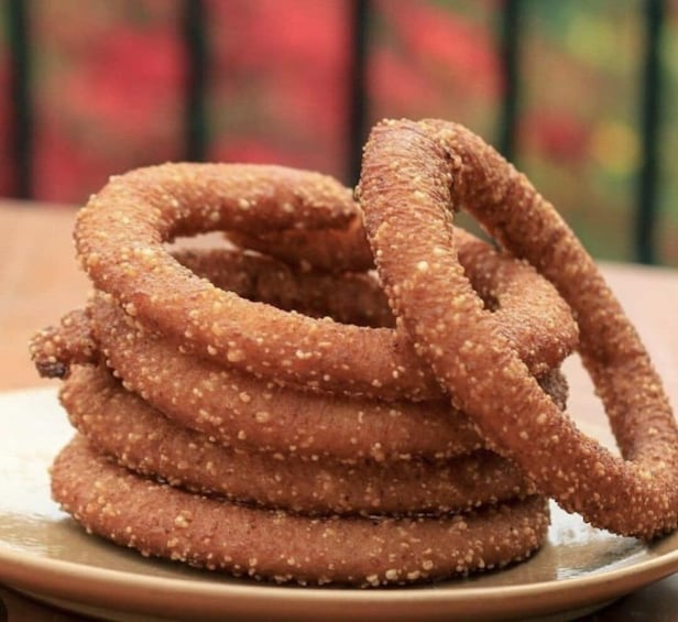 A stack of sesame-coated onion rings on a plate. 5