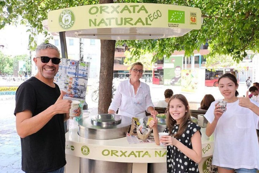 Ein Imbissstand mit einem Schild, auf dem 'ORXATA NATURAL ECO' steht. 3