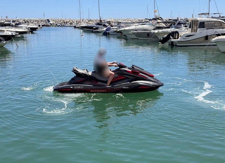 A person riding a jet ski on calm water with boats in the background. 1