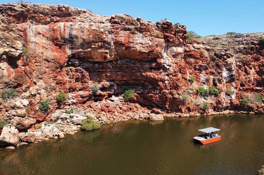 A river with a rocky cliff and a boat. 3