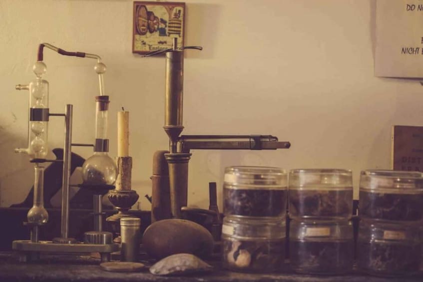 A vintage laboratory with glassware, a Bunsen burner, and jars of substances. 2