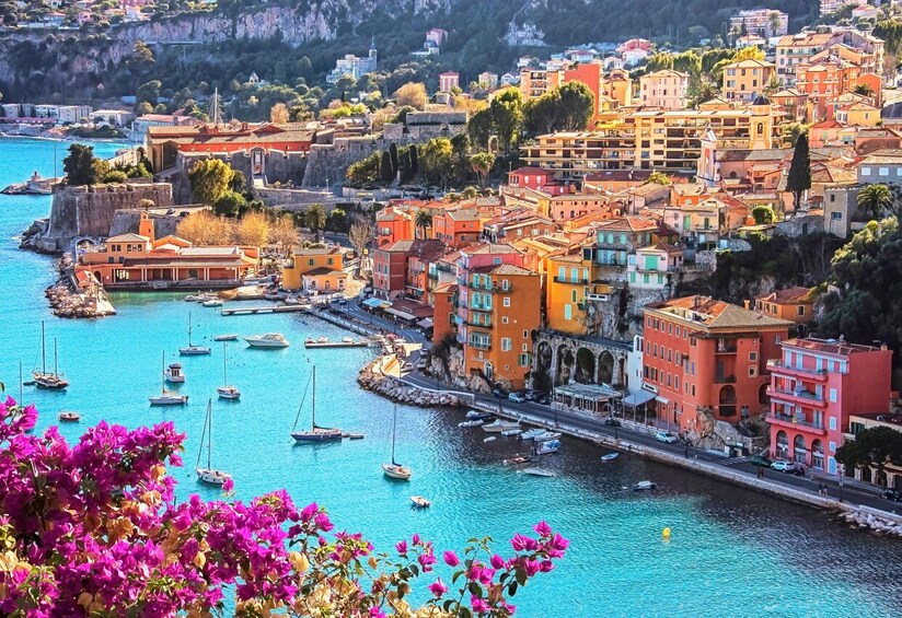 A coastal town with colorful buildings, a harbor with boats, and a cliff overlooking the water. 3