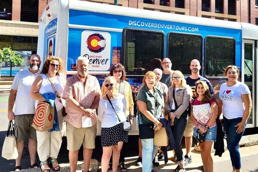 En grupp människor som står framför en buss från reseföretaget Discover Denver Tours. 5