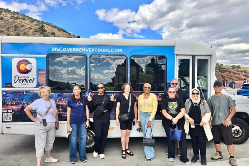En grupp människor som står framför en buss med texten ”Discover Denver Tours” på. 4