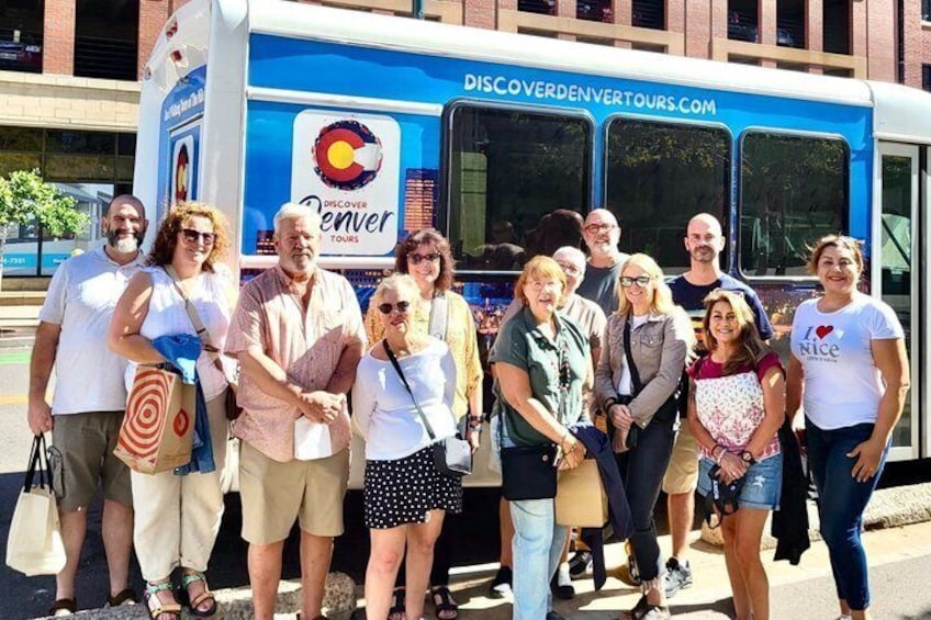 Un groupe de personnes se tient devant un autobus de la compagnie Discover Denver Tours. 3