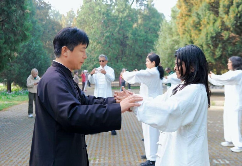 People practicing martial arts in an outdoor setting with trees in the background. 1