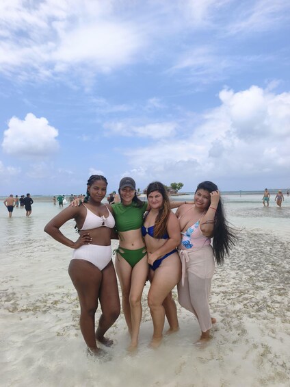 A group of people on a beach with clear skies and calm waters. 5