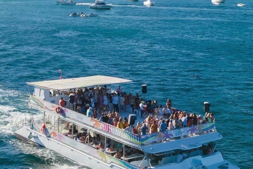 Un bateau rempli de monde sur le pont, entouré d’une eau bleue et calme et d’autres bateaux. 4