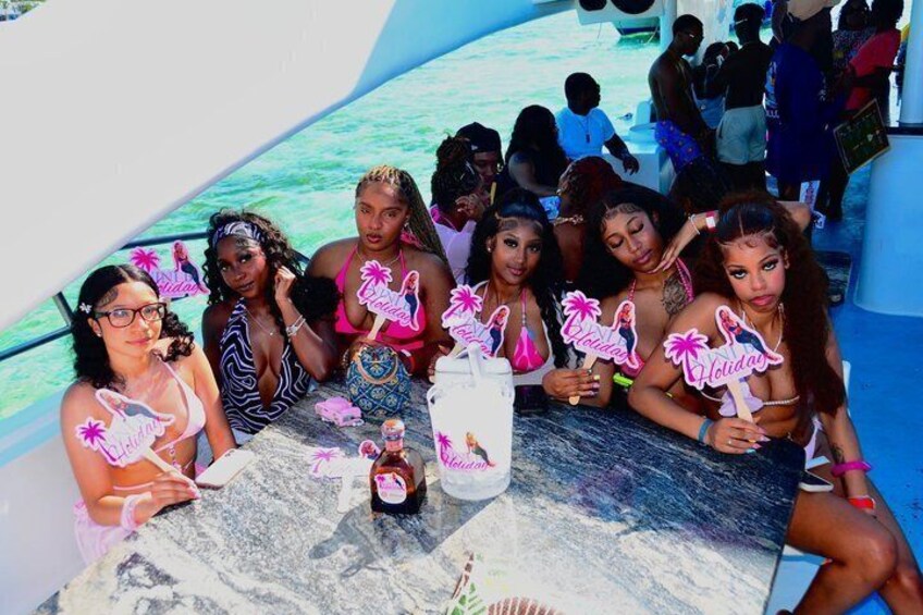 A group of people on a boat with a clear blue water background. 1