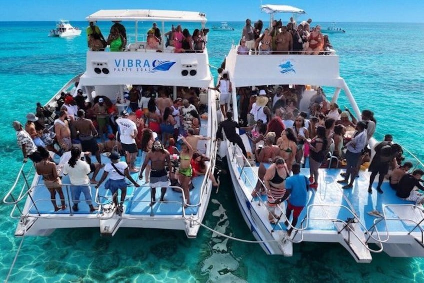 Two boats with people on them, surrounded by clear blue water. 5