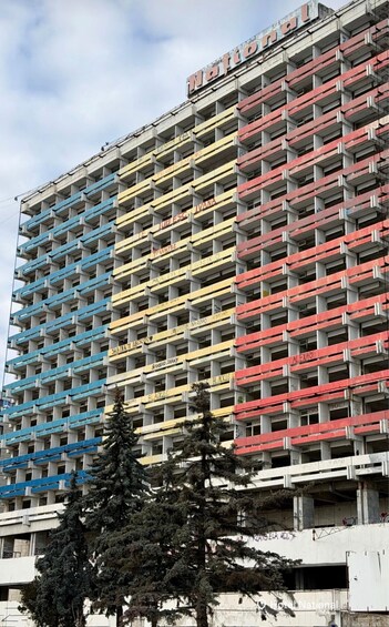 A multi-story building with balconies, some with graffiti. 3