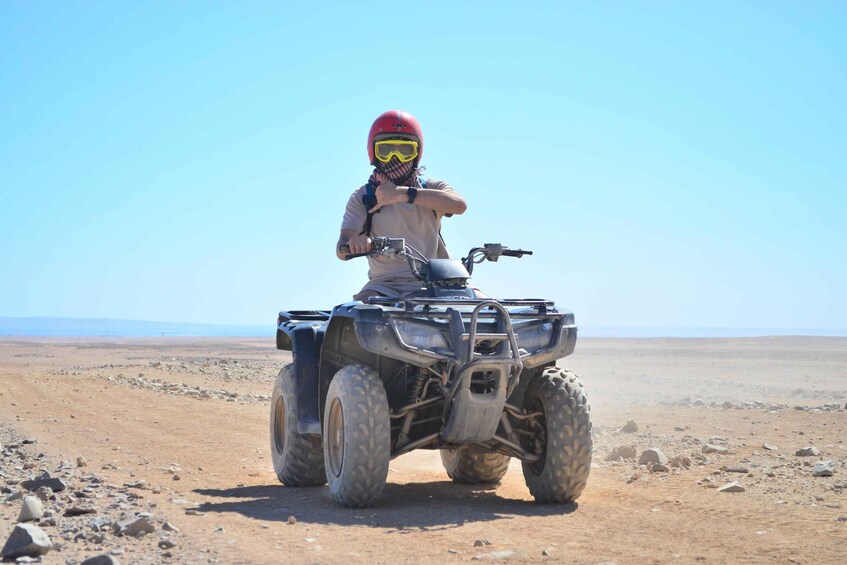 A person on a quad bike in a desert landscape. 5