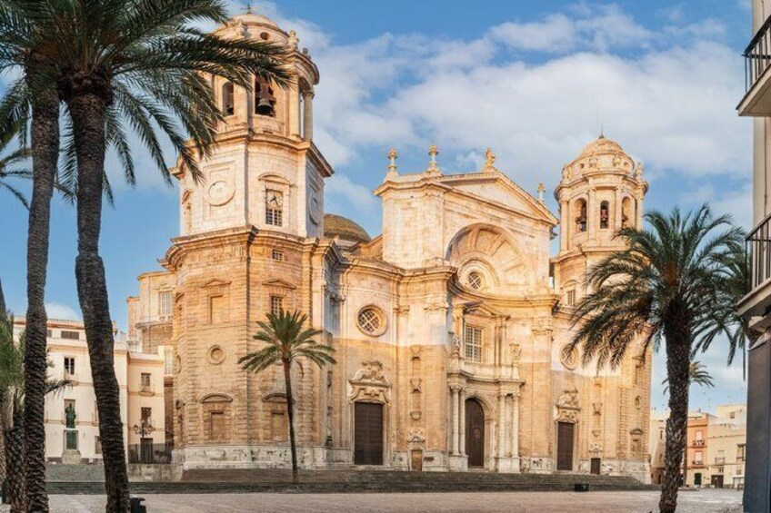 A historic church with a bell tower and dome, surrounded by palm trees. 2