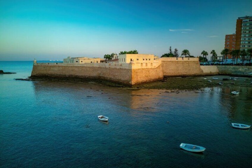 A fortified structure by the sea with boats in the water. 3