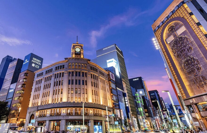 A cityscape with a historic building featuring a clock tower, surrounded by modern high-rise buildings. 1