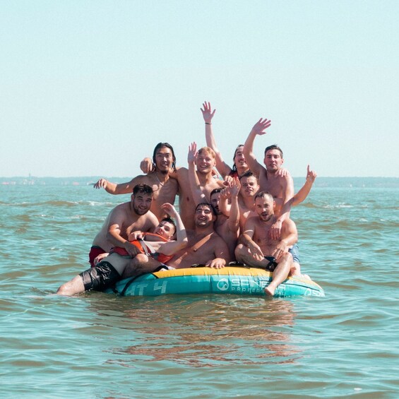 A group of people on a watercraft in the ocean. 2