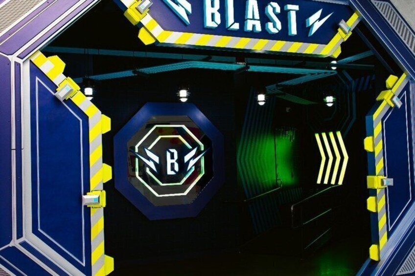 L'ingresso di un tunnel con un neon che riporta la scritta 'BLAST' e un logo esagonale con una 'B' al centro. 2