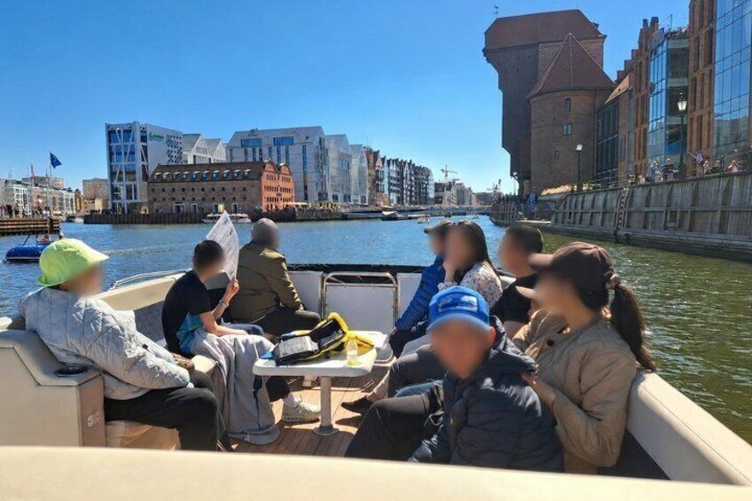 A group of people on a boat with a cityscape in the background. 5