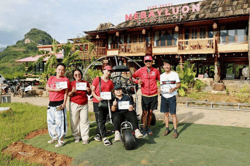 A group of people posing in front of a restaurant with a mountainous backdrop. 2