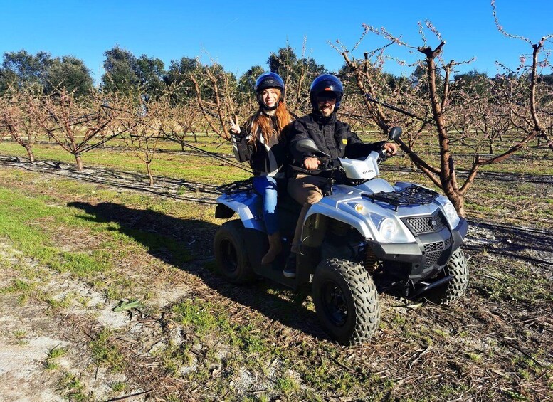 Two people on an ATV in a vineyard. 4
