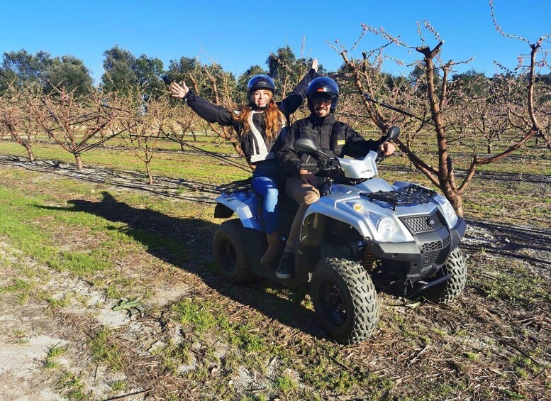 Two people on an ATV in a vineyard. 1