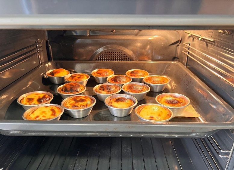 An oven with multiple ramekins containing custard dishes. 2
