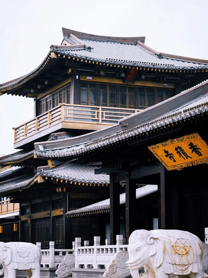 A traditional multi-tiered building with ornate roof tiles and a wooden balcony. 1