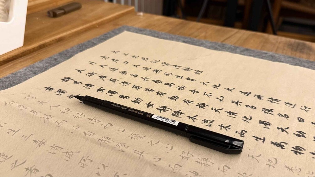 A calligraphy brush on a piece of paper with Chinese characters. 5