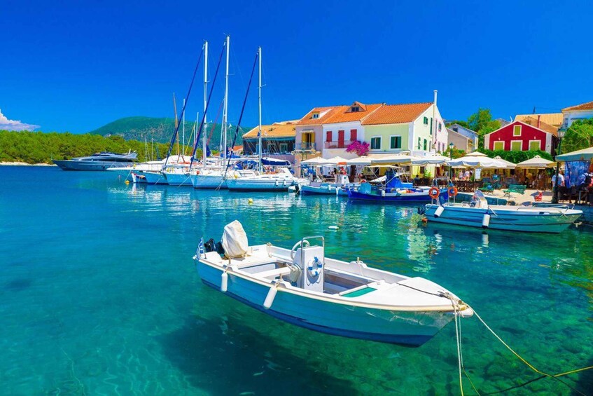 A coastal village with colorful buildings, a marina with boats, and clear turquoise waters. 3