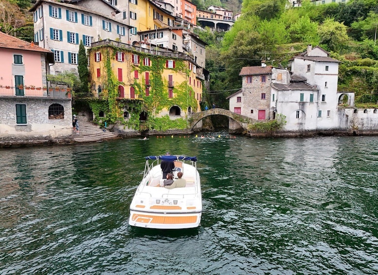 A boat on a river with buildings on the banks. 2
