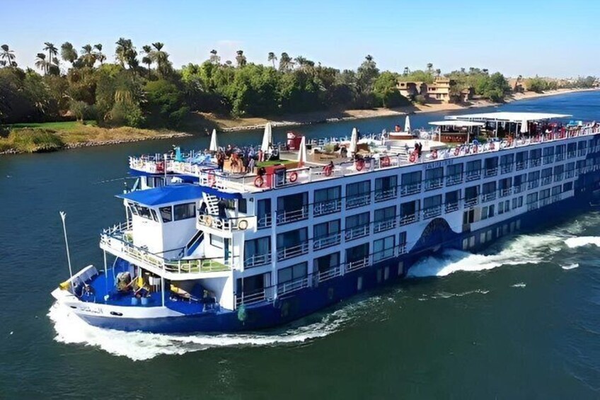 A large river cruise ship with multiple decks and passengers. 1