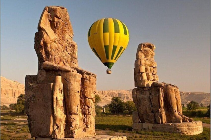 Ancient stone statues, a hot air balloon, and a desert landscape. 5