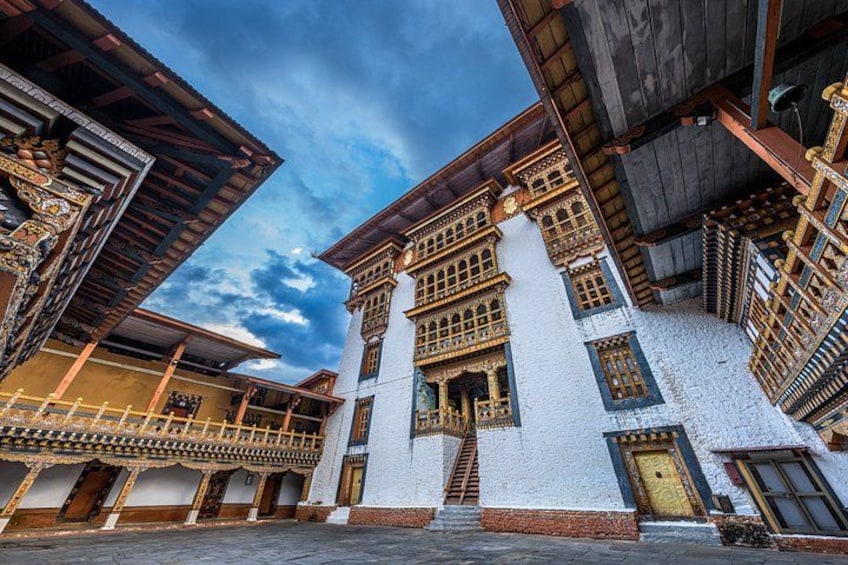 A traditional building with ornate wooden balconies and a white facade. 1