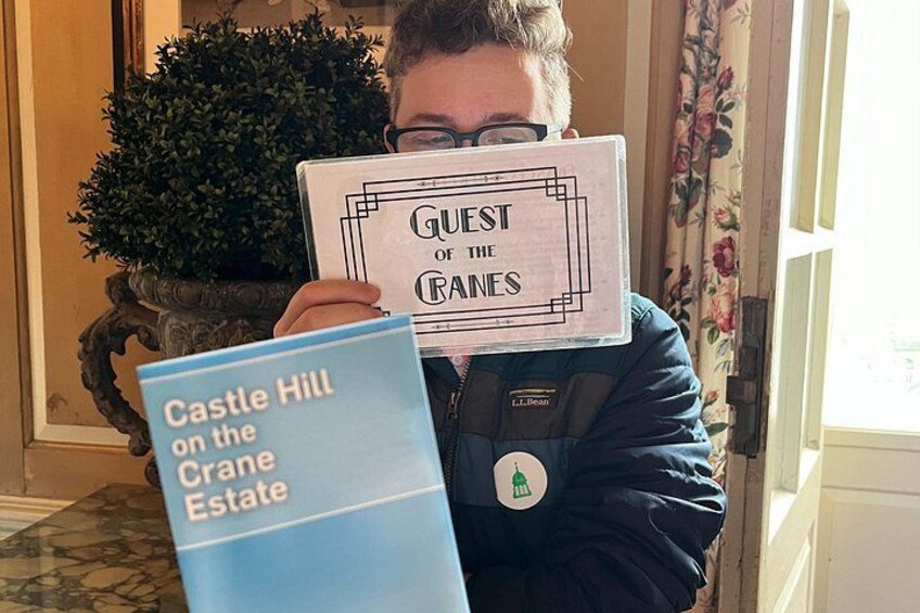 Una persona sosteniendo un libro titulado 'Castle Hill on the Crane Estate' y otro libro titulado 'Guest of the Graves'. 4