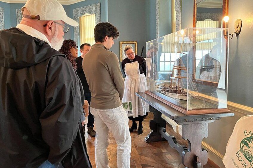 A group of people observing a historical exhibit in a museum. 2