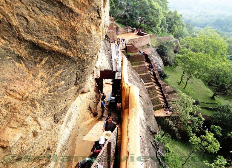 A stone bridge over a deep gorge with people walking on it. 2