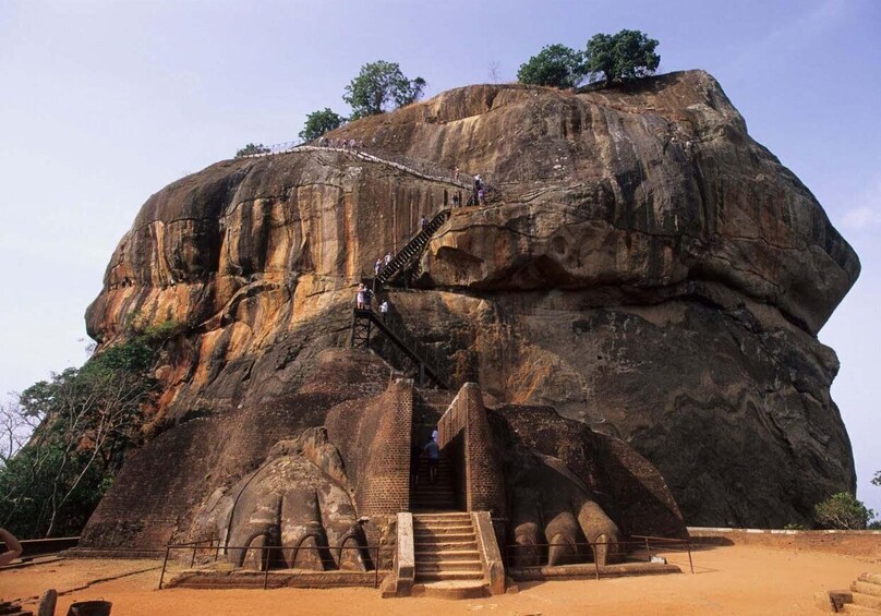 A large rock formation with a staircase leading to a temple entrance. 3