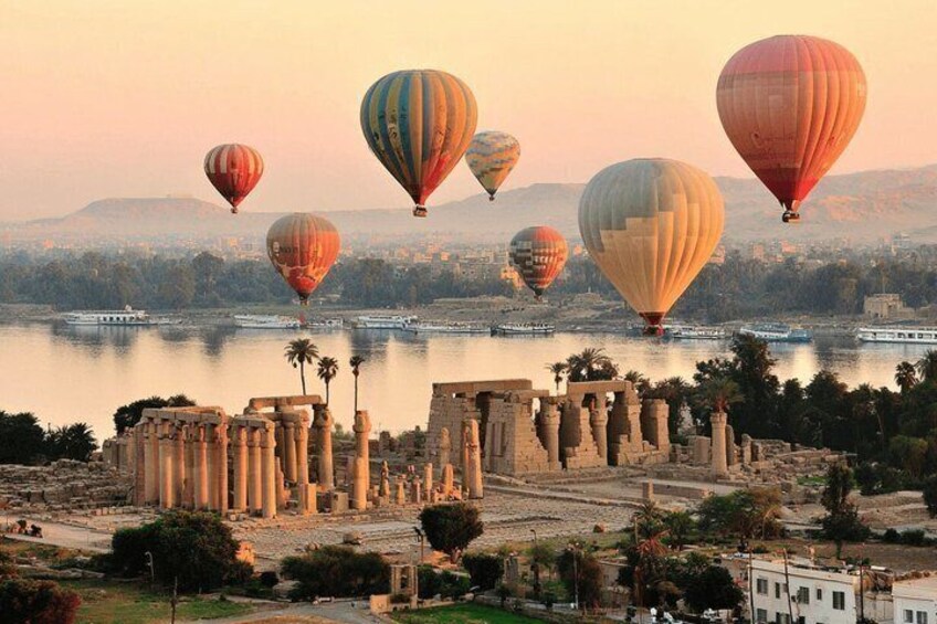 A historical site with ancient ruins and hot air balloons in the background. 5