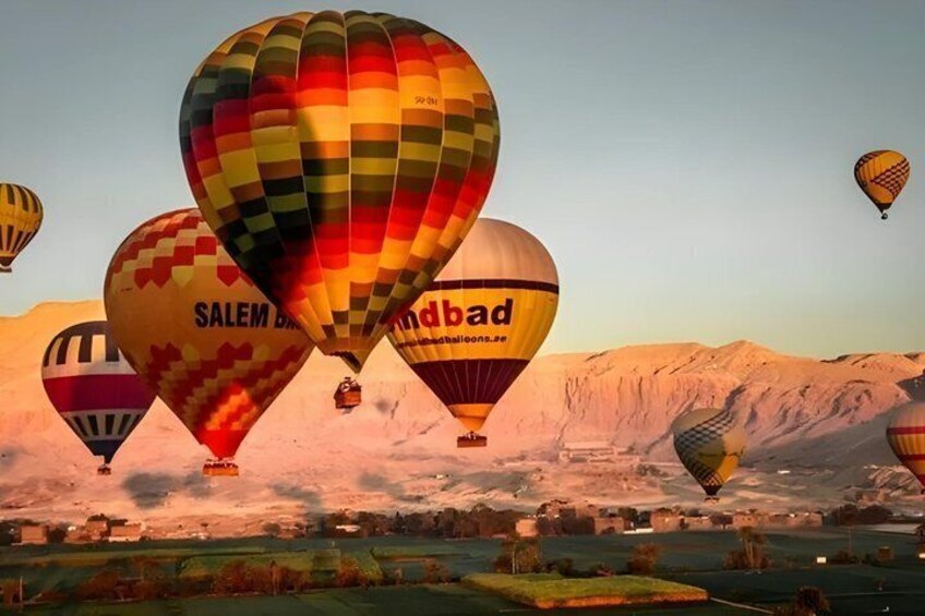 Hot air balloons over a landscape with mountains in the background. 4