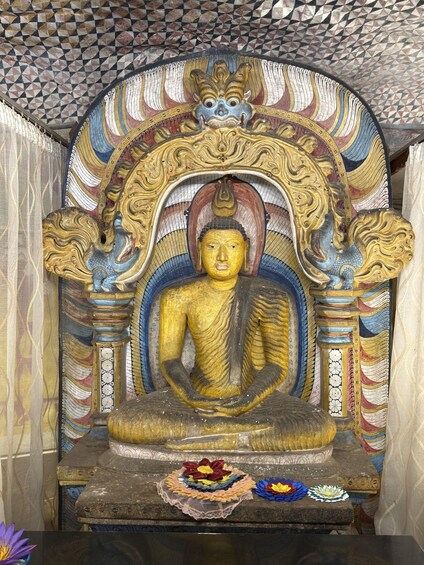 A golden Buddha statue in a temple with intricate designs and colorful decorations. 5
